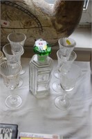 Glass decanter with green stopper & wine glasses.