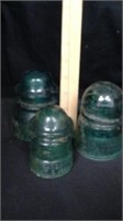 Three vintage green glass insulators