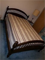 Full sized bed with a wood headboard and footboard