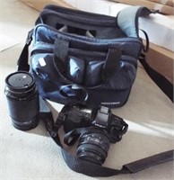 Minolta camera with accessories and bag.