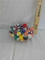 Large group of small pool balls in glass bowl