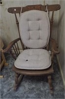 Antique wood rocking chair with padded seat.