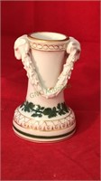 Porcelain candle stick with rams heads it looks