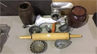 Two pottery jugs, meat grinder, rolling pin,