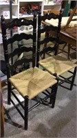 2 black painted ladder back chairs, woven seats,