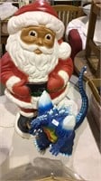 Dark face blow mold Santa and a blue Godzilla toy