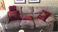 Large couch with decorative pillows and throw