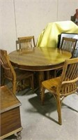 Oak pedestal table with 4 chairs has leaves