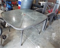 Glass top patio table with four chairs. Table