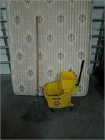Large mop with mop bucket and wringer.