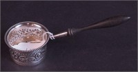A silver tea strainer marked sterling with wood