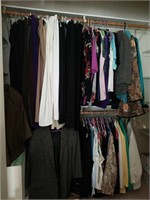 Closet full of clothes, sweaters, pants, skirts,