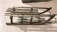 Antique sled with one broken slat has the metal