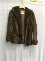 A woman's hip length, brown mink fur coat, seems t