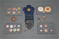 28 buttons/lapel pins, mostly Red Cross.