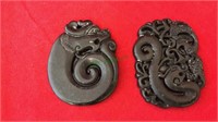Two carved stone disc, each one has a hole in it