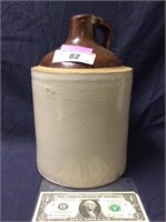 Vintage stoneware whiskey jug/crock has chip