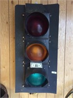 Stop light mounted on a board for hanging