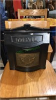 Cast metal mailbox with bronze tone leaf in the