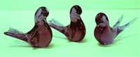 Three red art glass bird figures