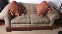 Green and red loveseat with two matching pillows,