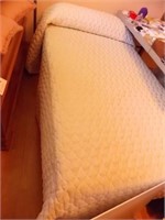 Twin bed, complete with bedspread and pillow