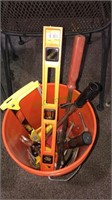 Bucket of tools including level, hammer, Saul,