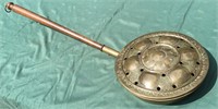 Big brass bed warmer with long wooden handle.
