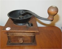 Coffee grinder with wood base and single drawer.