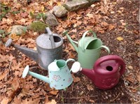 Four watering cans.