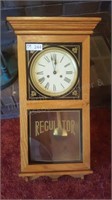 Regulator clock in oak cabinet