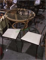 Two metal patio chairs in a bamboo glass top