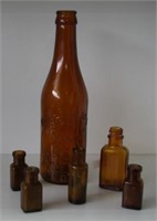 Six early amber coloured glass bottles
