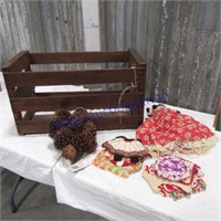 Wood crate with doll, pinecones, crocheted hotpads