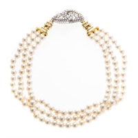A Triple Strand Pearl Necklace with Diamond Center