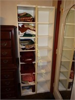 Two white shelving units with contents, each one