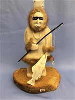 11 1/2" bone carving of an eskimo fisher with bone