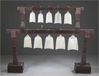 Set of ten Chinese white jade carved bells on wood