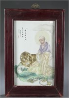 A Chinese porcelain tile of a man and tiger.