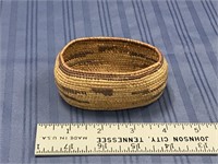 A tightly woven grass basket, unusual oval shape,