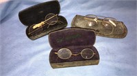 Three pairs of antique eyeglasses with the cases