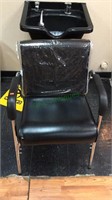 Black vinyl shampoo arm chair, with plastic cover