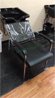 Black vinyl shampoo arm chair, with plastic cover