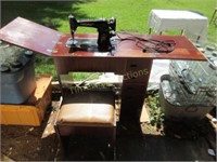 Black singer sewing machine in cabinet