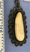 Fossilized ivory and sterling silver pendant on ch