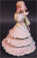 A Cybis figurine of a young girl with a yellow