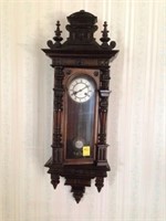 Hanging pendolem clock w/ ornate woodwork