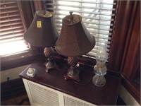 2 brown lamps and an old oil lamp