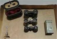 Binoculars, bell, and advertising tin