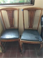 pair of wood chairs with leather seats